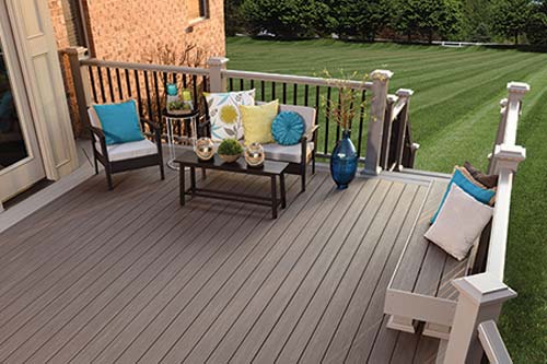 Brown wooden deck with chairs and small table.