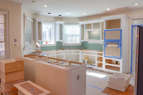Living room view of kitchen. White cabinets.