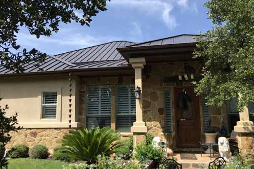 Stone and stucco house with front door pillars. 